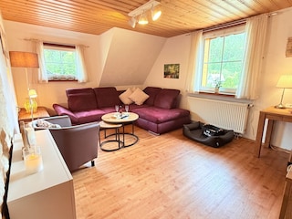 gemütliches Wohnzimmer mit Ecksofa und Elektrokamin