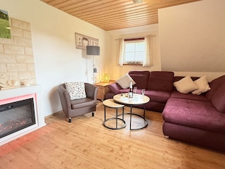 gemütliches Wohnzimmer mit Ecksofa und Elektrokamin