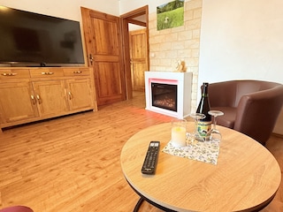 gemütliches Wohnzimmer mit Ecksofa und Elektrokamin