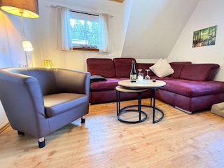 gemütliches Wohnzimmer mit Ecksofa und Elektrokamin