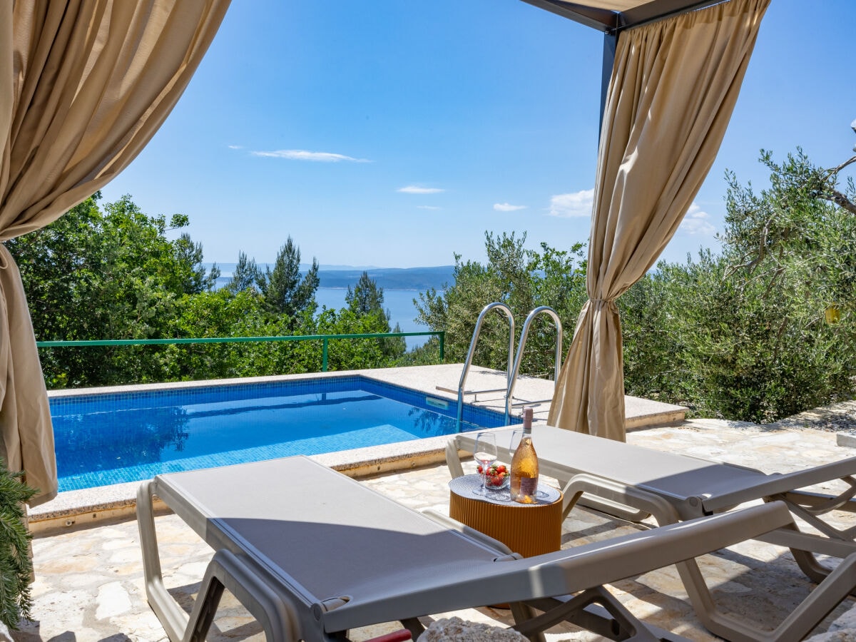 Überdachte Loungeecke am Pool mit Meerblick