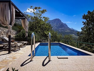 Der Pool mit Sonnenliegen und Lounge