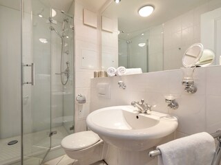 Bad mit Dusche, WC, Handtuchtrockner und Fön.