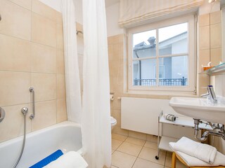 Bad mit kleiner Sitzwanne und integrierter Dusche.