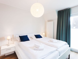 Schlafzimmer mit Fernseher und großem Kleiderschrank