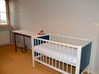 Das Schlafzimmer mit Doppelbett und Kinderbett