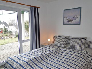 Schlafzimmer 1 mit Doppelbett und Zugang zur Terrasse