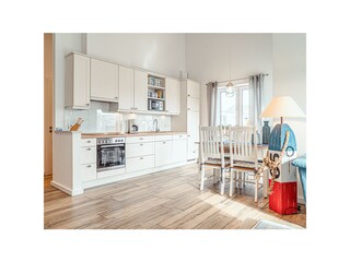 Gut ausgestattete Einbauküche mit Essgruppe