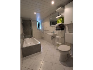 Großes Badezimmer mit Dusche und Badewanne