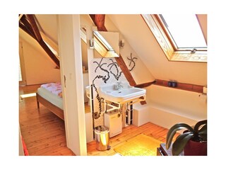 blaues Haus Bad oben mit Blick ins Schlafzimmer