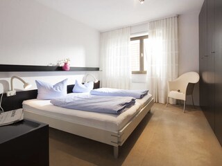 Das Schlafzimmer mit Doppelbett und Kleiderschrank