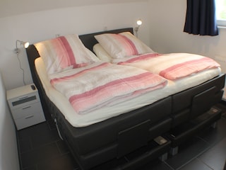 ...Boxspringbett, mit je einem Fernseher und einem...