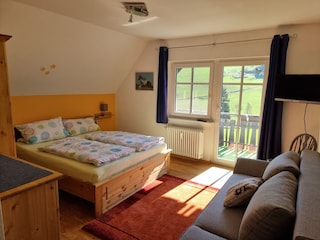 zweites Schlafzimmer mit Sofa und TV