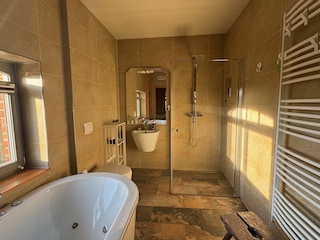 Bad mit bodengleicher Dusche und Whirlwanne
