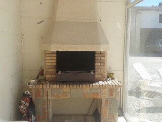 Grill neben der Terrasse mit Glaswand