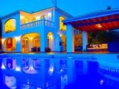 Villa at sunset with blue pool light