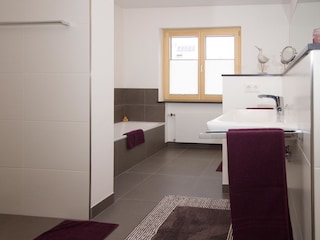 Hauptbadezimmer mit Badewanne und bodengleicher Dusche