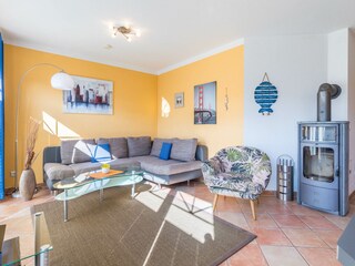 Wohnzimmer mit Ecksofa und Kaminofen