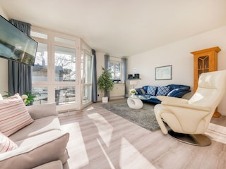 Das große helle Wohnzimmer mit Austritt zum Balkon ...