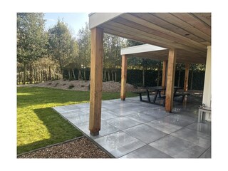 Große überdachte Terrasse mit Lounge-Bereich und Esstis