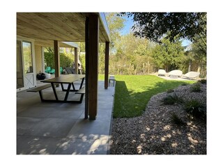 Große überdachte Terrasse mit Lounge-Bereich und Esstis