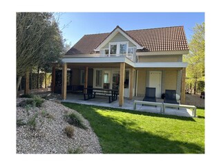 Große überdachte Terrasse mit Lounge-Bereich und Esstis