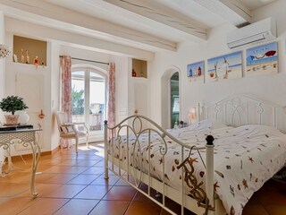 Master bedroom on 1st floor with doors to balcony