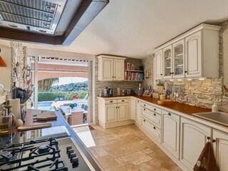 Kitchen from other side with doors to outside dining