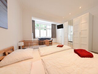 Schlafzimmer 1 mit Doppelbett, Kinderbett und TV