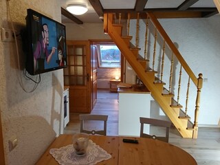Wohnbereich mit Tür zum Schlafzimmer und Treppe ins DG