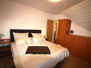 Gräumiges Schlalfzimmer mit Doppelbett und Rollläden.