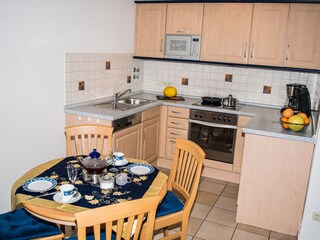 Ferienwohnung Bäumer - Esstisch und Küchenzeile