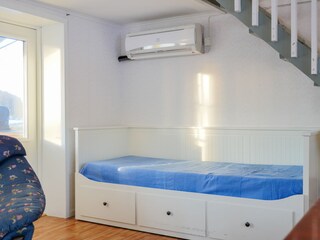 Bed im Wohnzimmer unter der Treppe ins Obergeschoss