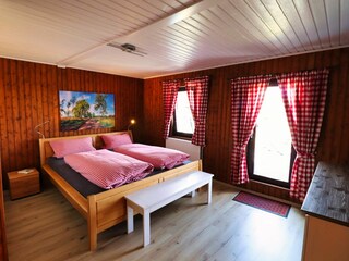 Schlafzimmer mit Zugang zur Terrasse und Bad