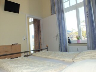 Schlafzimmer mit Doppelbett und TV