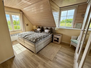 Sonniges Schlafzimmer mit hochwertigem Boxspringbett.