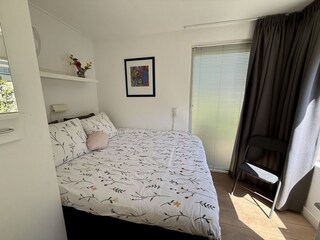 Schlafzimmer mit Doppelbett und Kleiderschrank