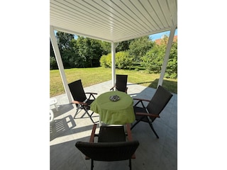 Überdacht im freien Sitzen - die Terrasse hinten