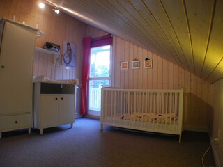 Kinderzimmer mit Babybett und Wickelkommode