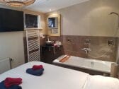 Schlafzimmer mit Smart TV  und 2 Persons Badewanne