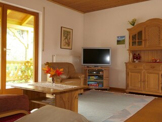Wohn-/Esszimmer mit Flach-TV und Balkontür