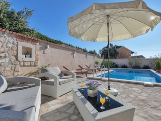 Der Pool mit Sonnenliegen und Meerblick