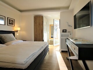 Schlafzimmer mit TV und ebenfalls mit Zugang zum Balkon