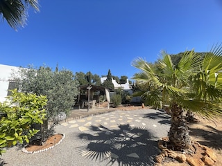 Gartensicht auf Holzterrasse und Pavillon
