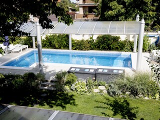 Solar heated swimming pool with sun terrace