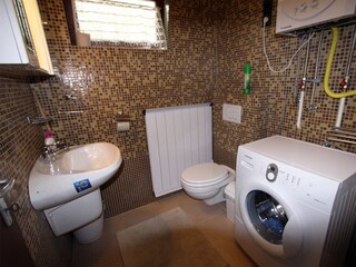 Bathroom with tub and washing machine on the ground flo