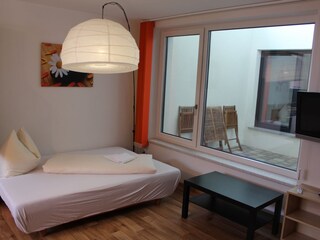 Living room/kitchen with view of the outdoor area and atrium