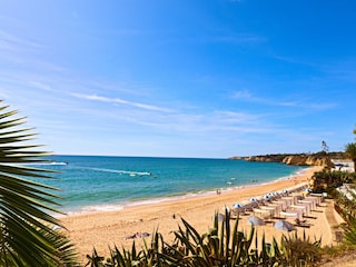 endlos Strand mit Felsen/Klippenbeginn ganz rechts