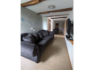 Langer Flur mit großem Sofa uns Sitzmöglichkeiten