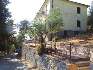 Haus liegt an kleiner Strasse oberhalb des Dorfes